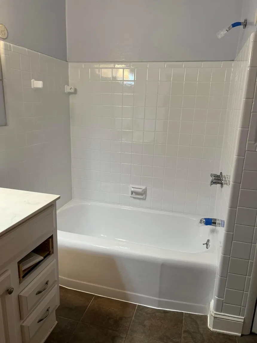 A refinished bathtub and tile surround, both finished in white.