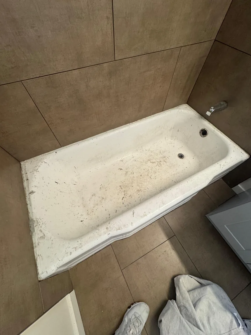 A worn, scratched bathtub before refinishing.