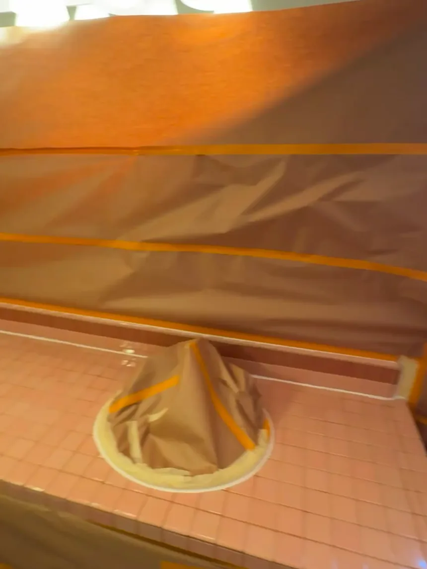 A tile countertop masked off for spraying, sink covered with paper and tape.