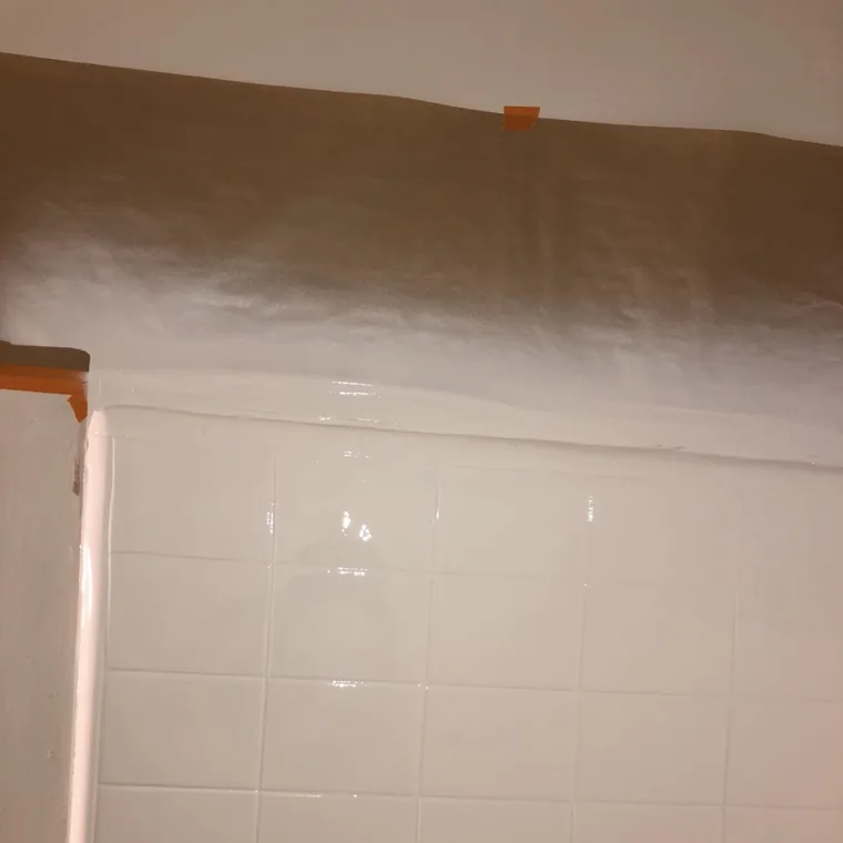 The finished wall masked off above and coated, glossy and even.