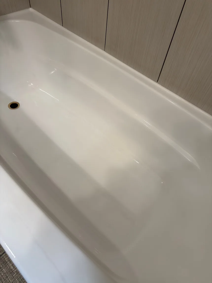 A close view of a finished bathtub, the new surface even and glossy.